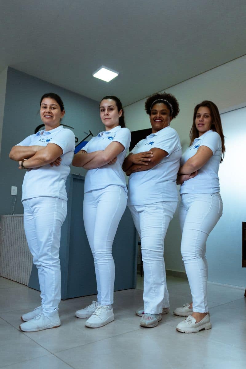 Quatro profissionais da equipe técnica de braços cruzados